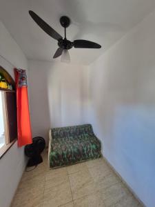 a living room with a ceiling fan and a green couch at Nataliana's House in Cabo Frio