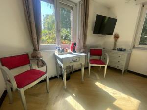 a room with a desk and two chairs and a tv at Gîtes chez julie in Beaucamps-Ligny