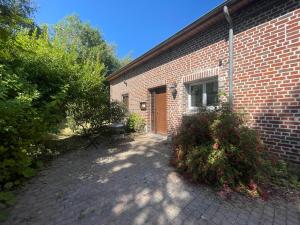 a brick building with a door on the side of it at Gîtes chez julie in Beaucamps-Ligny