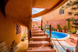 a staircase leading up to a house with a swimming pool at Maison Sahel - African Art & Coastal Serenity in Dakar