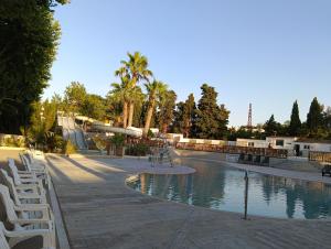 a swimming pool with chairs and a skate park at Mobil Home AGDE Hérault in Agde