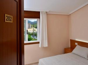 a bedroom with a bed and a window at Pension As Termas in Bubaces