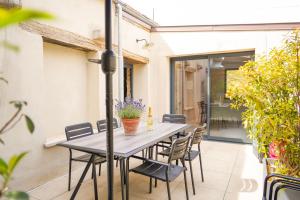 a table and chairs on the patio of a house at La Parenthèse Bourguignonne in Savigny-lès-Beaune +25 photos