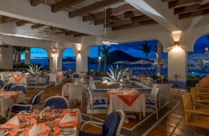 a restaurant with white tables and chairs and the ocean at Pueblo Bonito Los Cabos Blanco Beach Resort - All Inclusive in Cabo San Lucas