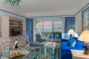 a living room with a blue couch and a view of the ocean at Pueblo Bonito Los Cabos Blanco Beach Resort - All Inclusive in Cabo San Lucas