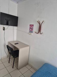 a room with a desk and a sign on the wall at Hotel Eduardo's in Rio do Sul