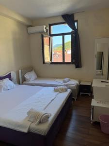 two beds in a room with a window at Center Side in Prizren