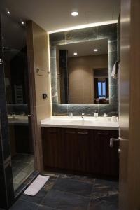 a bathroom with a sink and a large mirror at LUNAS Apartmani 7 in Kopaonik