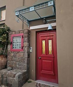a red door on the side of a building at MONI apartment in Perdika