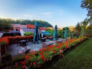 a garden with tables and umbrellas and flowers at Casa Adalmo in Sighişoara