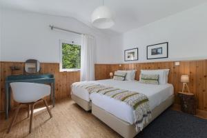a bedroom with a bed and a desk and a chair at Furnas Lake Forest Living in Furnas +77 photos
