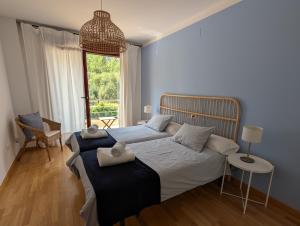 a bedroom with a bed and a chair and a window at Apartamento LLAR DEL CARES in Arenas de Cabrales