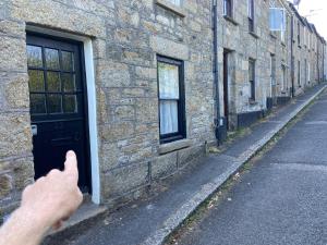 a person giving a thumbs up next to a building at 23 Leskinnick Terrace in Penzance +6 photos