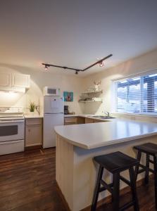 a kitchen with a counter and two stools in it at Snow Valley Lodging in Fernie