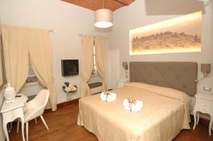 a bedroom with a bed and a table and chairs at B&B La Loggia e L’Orologio in Castiglione del Lago