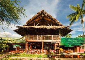 a large straw hut with a table and chairs at Decameron Decalodge Ticuna in Leticia