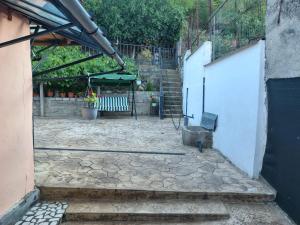 an outdoor patio with a bench and an umbrella at Casa La Bunica in Orşova