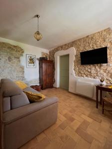 a living room with a couch and a tv on the wall at Casa del boscaiolo in Trevi