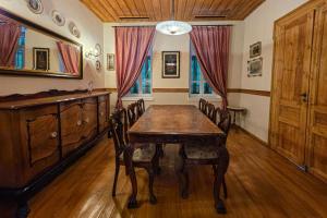 a dining room with a wooden table and chairs at Ξενώνας Λελέκι in Ayiá