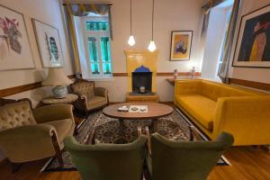 a living room with a yellow couch and chairs at Ξενώνας Λελέκι in Ayiá