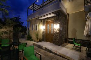 a stone house with a wooden door at night at Ξενώνας Λελέκι in Ayiá