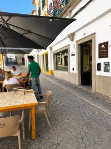 a man riding a skateboard on a table at a restaurant at Burgos Guest House in Évora
