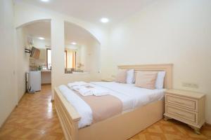 ein Schlafzimmer mit einem großen Bett mit weißen Laken und Kissen in der Unterkunft ОРЕЛ in Yerevan