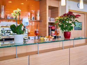 a counter with glasses of wine and flowers on it at Ibis Como in Grandate