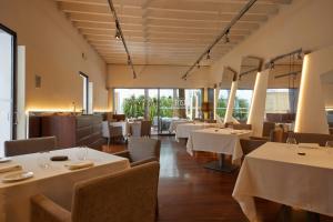 a restaurant with white tables and chairs and windows at Convent de la Missio - Grand Luxury Boutique hotel, Adults Only in Palma de Mallorca