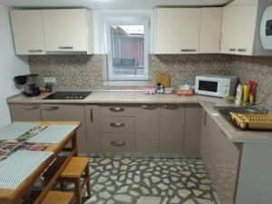 a kitchen with white cabinets and a microwave at Casa La Bunica in Orşova