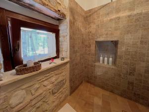 a bathroom with a shower with a window and a television at Casa del boscaiolo in Trevi +26 photos