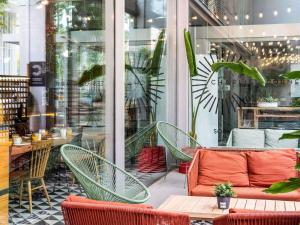 a patio with chairs and a couch in front of a store at Ibis Barcelona Plaza Glòries 22@ in Barcelona