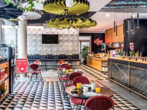 a restaurant with tables and chairs and a bar at Ibis Barcelona Plaza Glòries 22@ in Barcelona