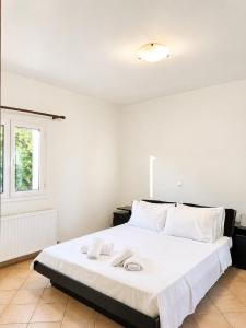 a bedroom with a large white bed with towels on it at Seascape Nafplio Residence in Vivari