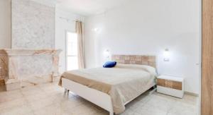 a bedroom with a bed with a blue pillow on it at Villa Blu Dea room & apartment in Torre Lapillo