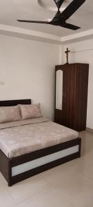a bedroom with a bed with a cross on the ceiling at Gods Gift in Murbād