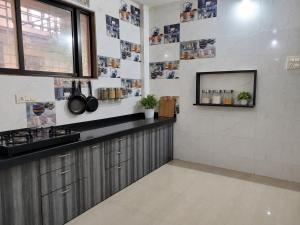 a kitchen with a counter and a tv on the wall at Gods Gift in Murbād +4 photos