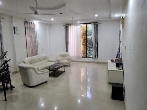 a living room with two chairs and a table at Gods Gift in Murbād