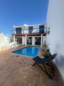 a villa with a swimming pool and a house at The White House - Zonnebloem in Cape Town