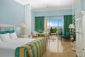 a bedroom with a bed and a living room at Pueblo Bonito Emerald Bay Resort & Spa - All Inclusive in Mazatlán +90 photos