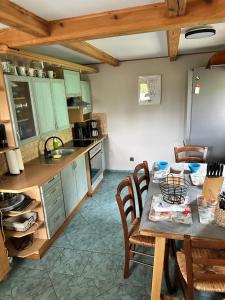 a kitchen with a table and some chairs and a table and a kitchen at Domek wypoczynkowy Nad Brdą in Przechlewo