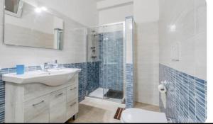 a bathroom with a sink and a shower with a toilet at Villa Blu Dea room & apartment in Torre Lapillo +22 photos