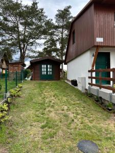 a barn with a green door and a grass yard at Domek wypoczynkowy Nad Brdą in Przechlewo +5 photos