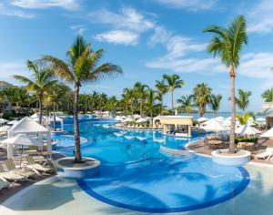 an image of a resort pool with palm trees and umbrellas at Pueblo Bonito Emerald Bay Resort & Spa - All Inclusive in Mazatlán