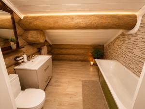 a bathroom with a toilet and a bath tub at Private lakeside holiday house with fireplace, sauna, hot tub - Ezernams Dzintars in Valdemārpils +29 photos