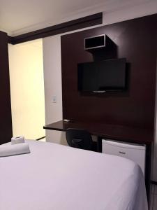 a bedroom with a white bed and a black wall at Hotel Sol Brasil in Fortaleza