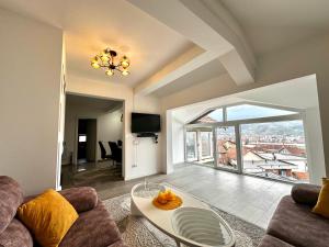 a living room with a couch and a table at Modern Penthouse with Unbeatable Panoramic Views in Peje +1 photo