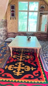 a table in a room with a rug on the floor at ЭКО -Балык  +12 photos