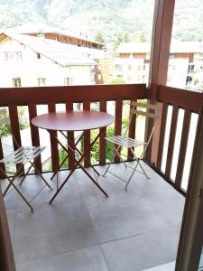 a table and two chairs on a balcony at Le 400 BIS in Bourg-Saint-Maurice