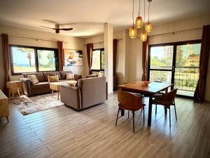 a living room with a table and a couch at Teranga Tides in Bijilo